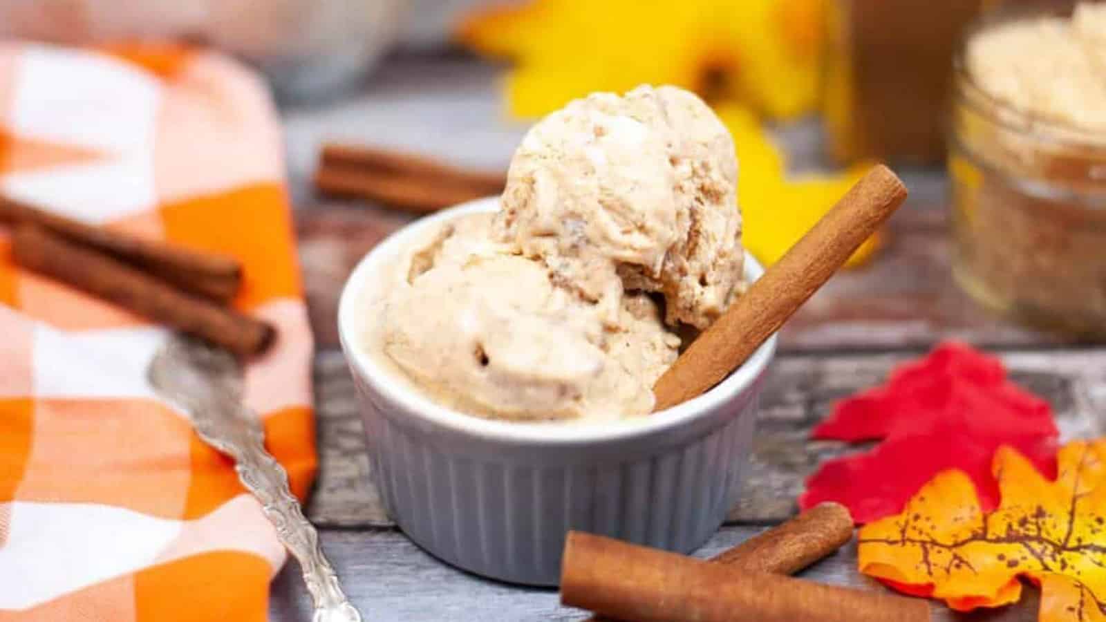 Low angle shot of a bowl of pumpkin spice ice cream with cinnamon sticks.