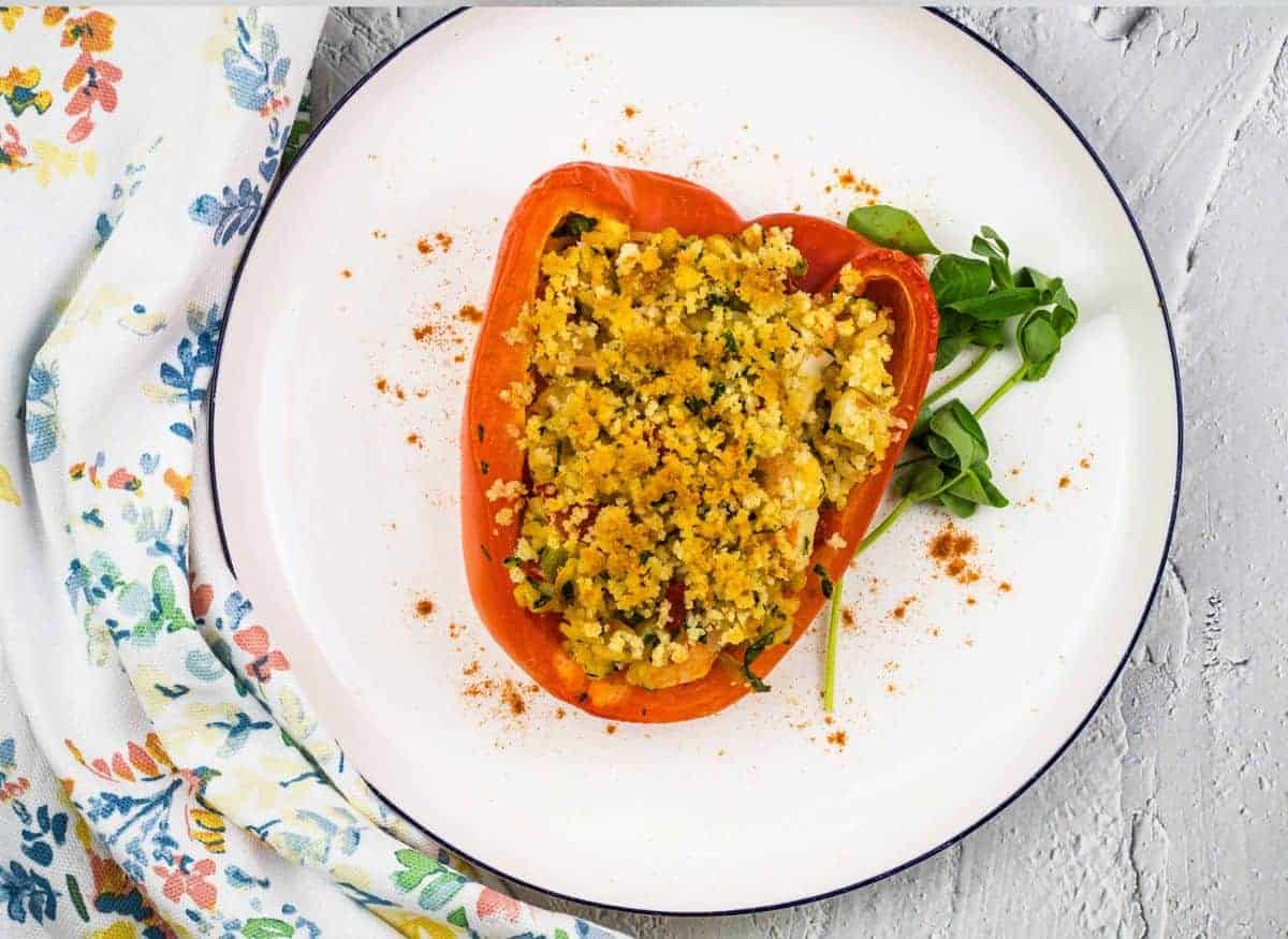 Stuffed red peppers on a white plate.