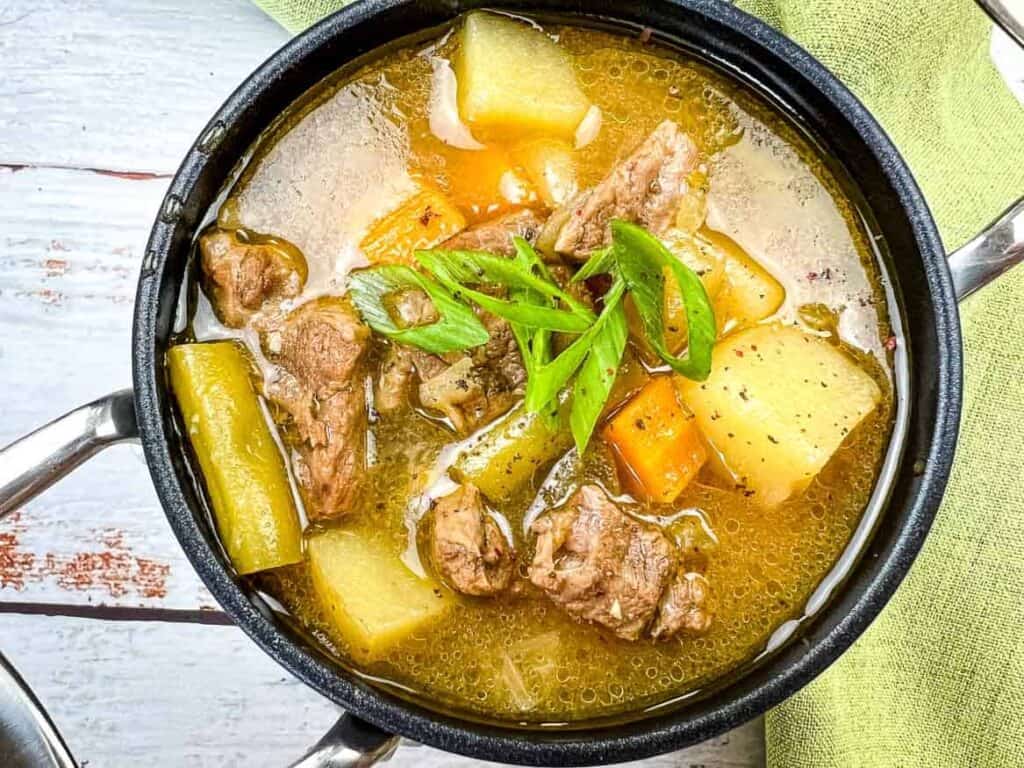 Steak & Potato Soup in a black bowl.