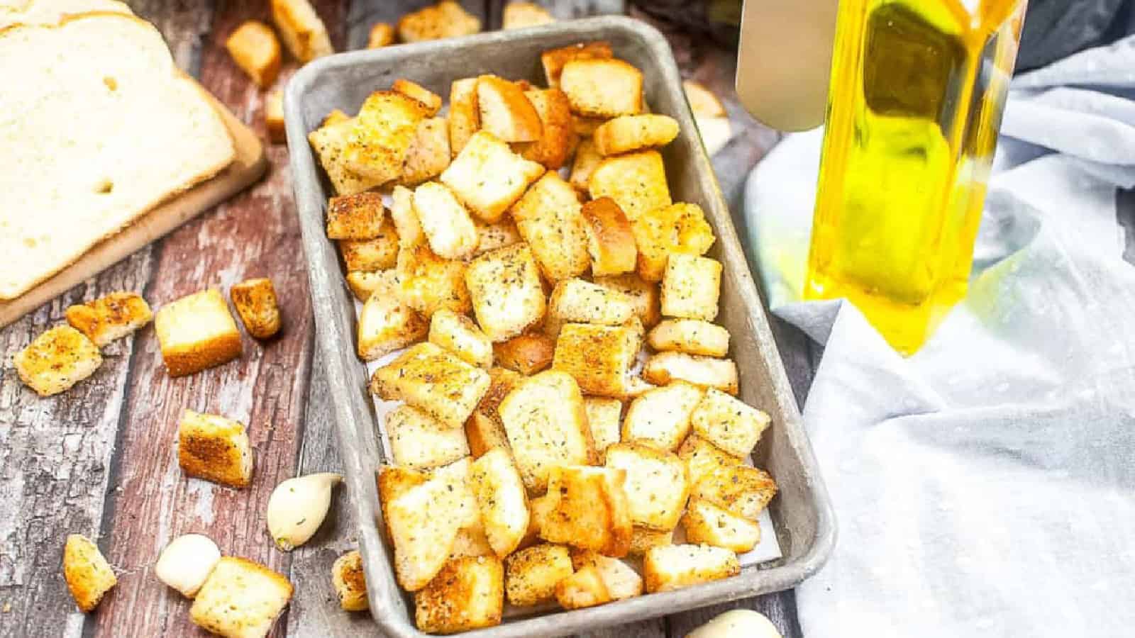 Low angle shot of croutons on a small metal baking sheet.