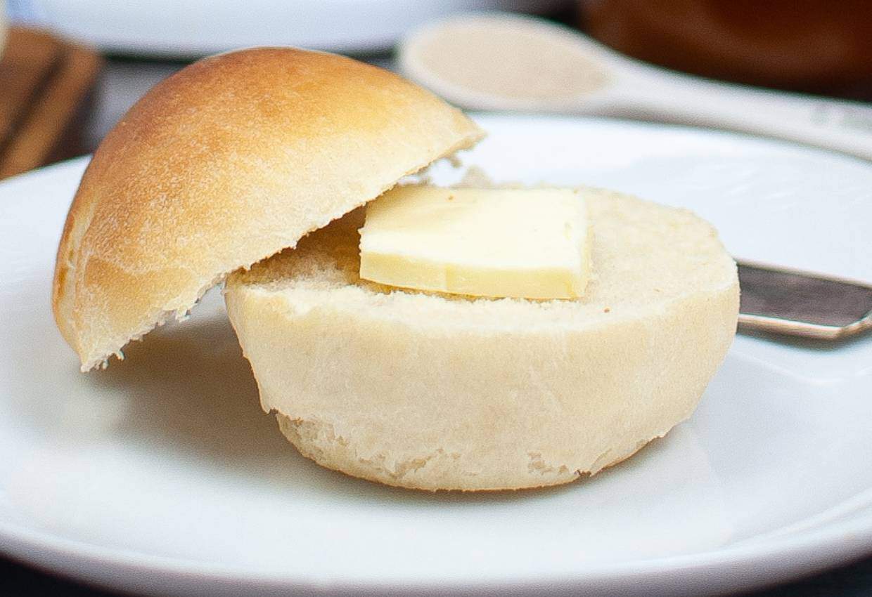 Homemade dinner roll plated with a butter pat.