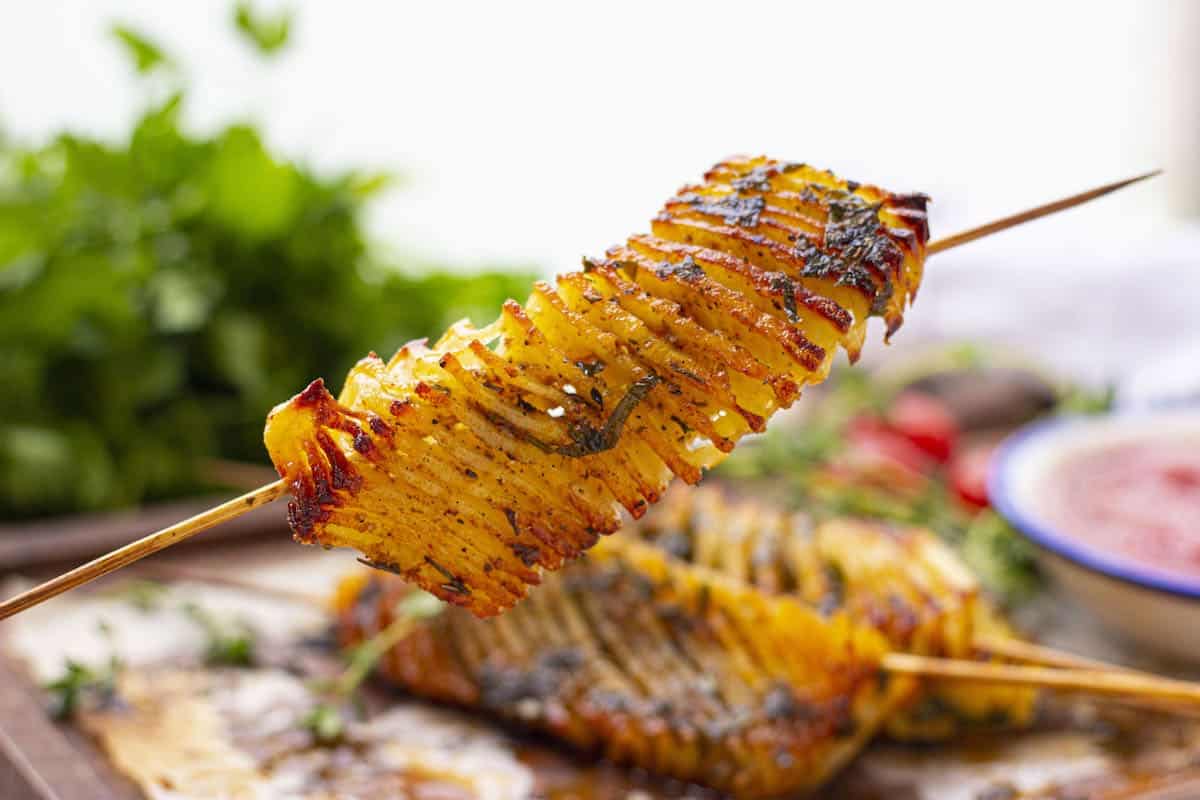 Accordion potatoes on a skewer seasoned with spices.