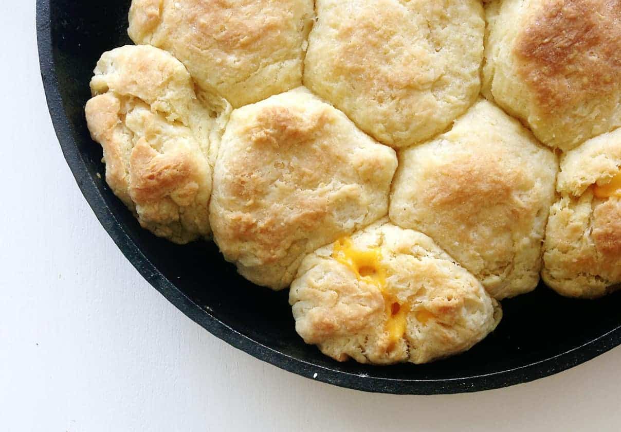 Cheesy biscuits in a skillet on a table.