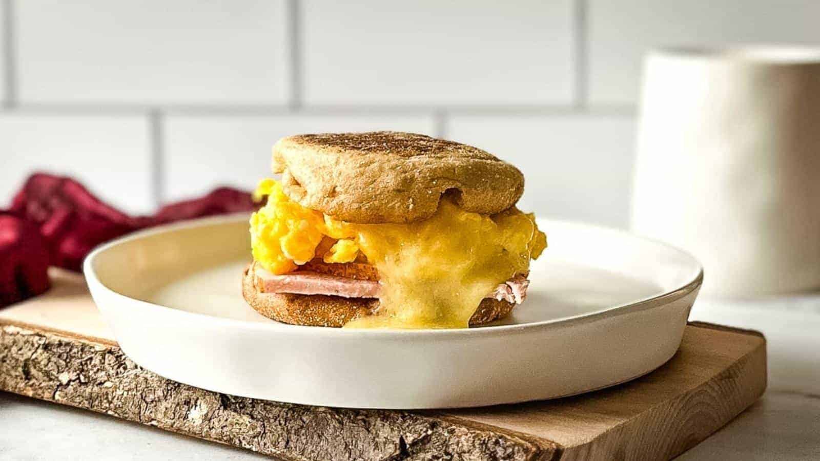 Side view of turkey egg and cheese sandwich on a white plate.