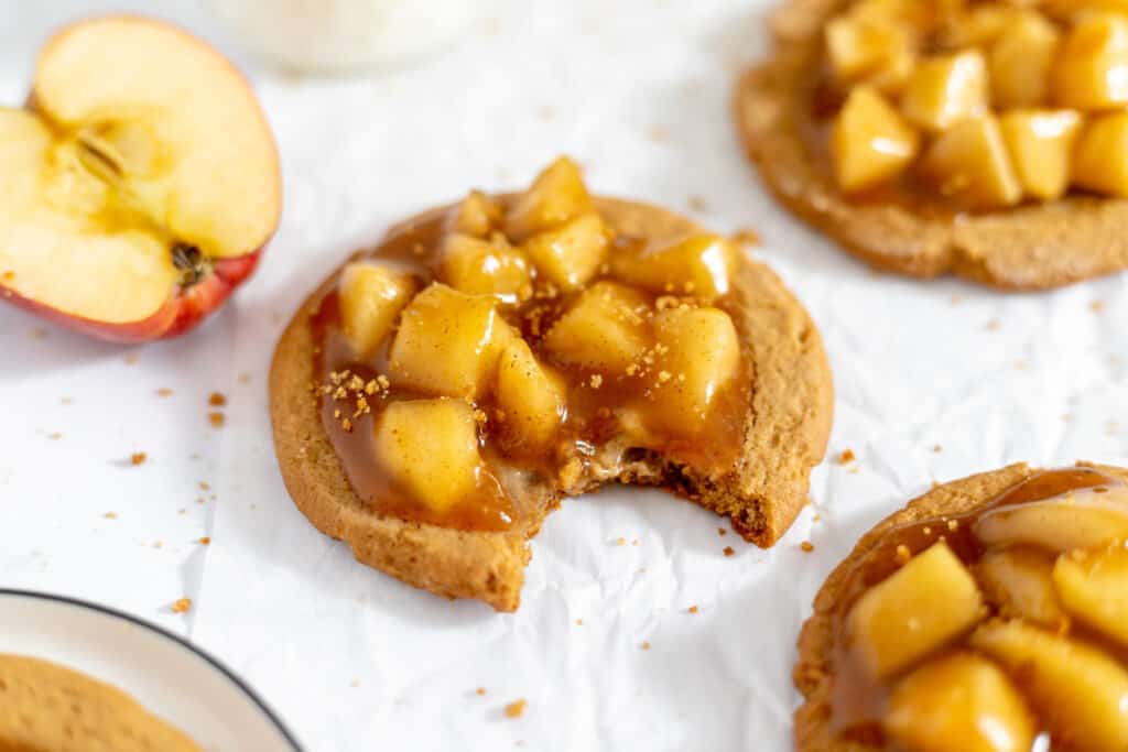 A plate of cookies with caramel and apples on it.