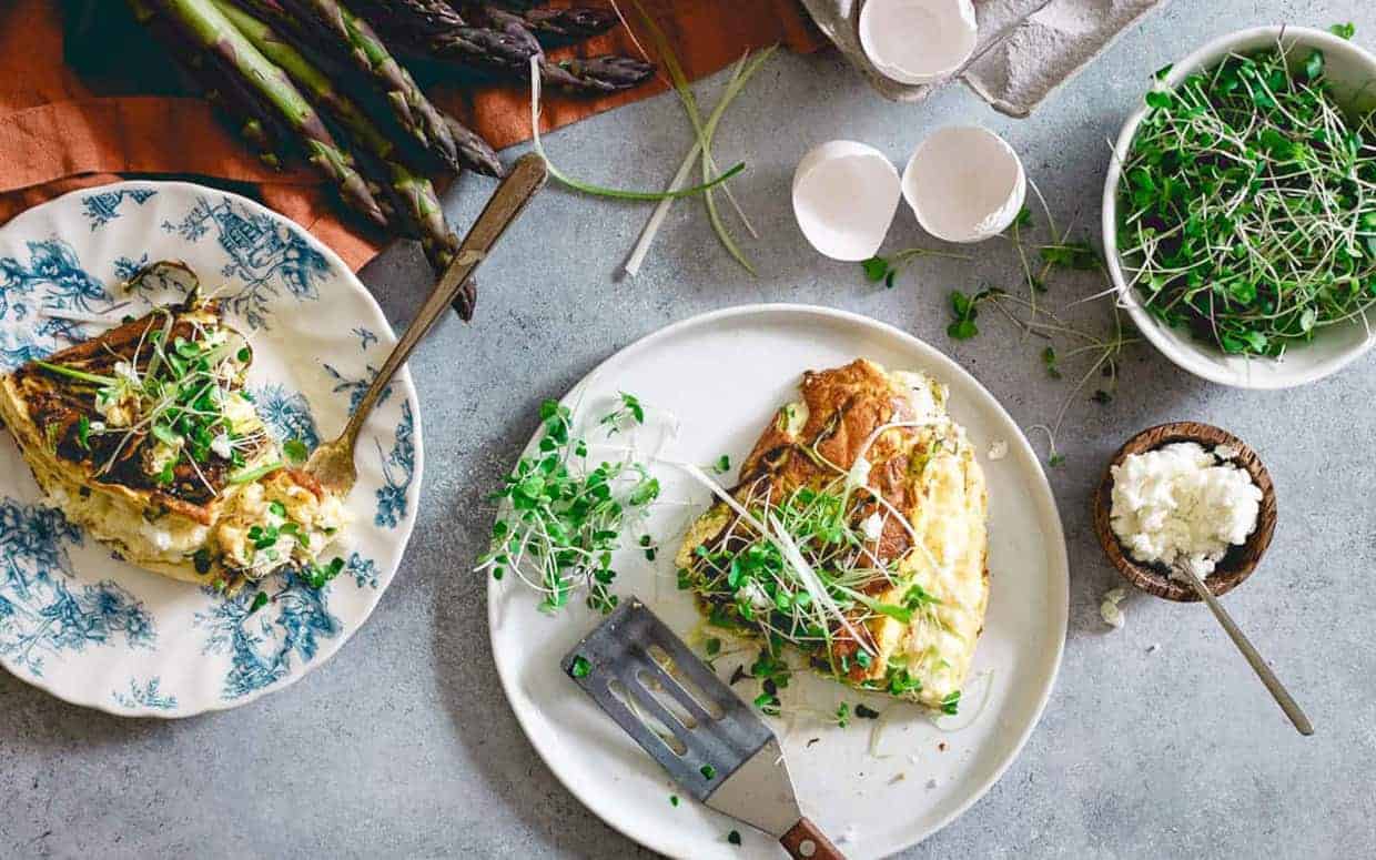 Asparagus Omelette Souffle slices on white plates.