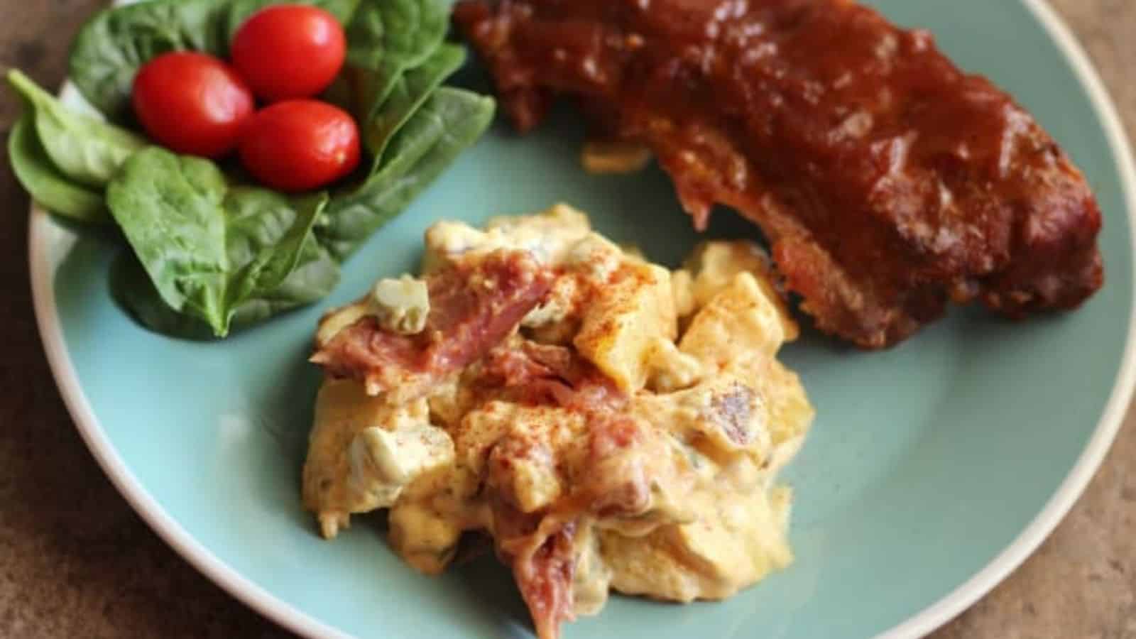 BBQ Rib Potato Salad on a light blue plate with a salad and ribs.