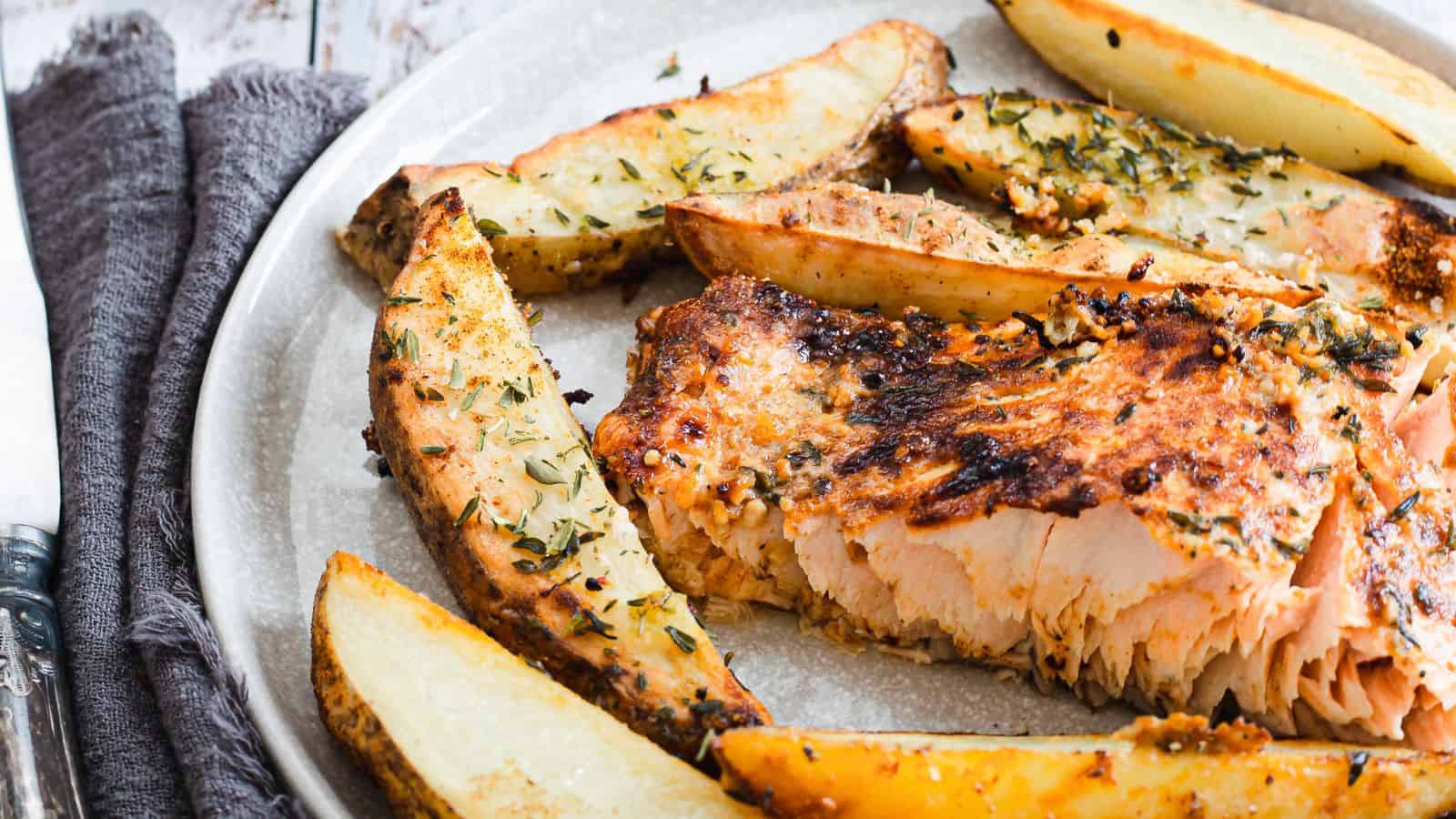 Grilled salmon and potatoes on a baking sheet.