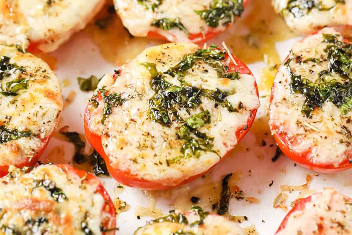 Baked tomatoes with Parmesan and mozzarella cheese garnished with parsley.