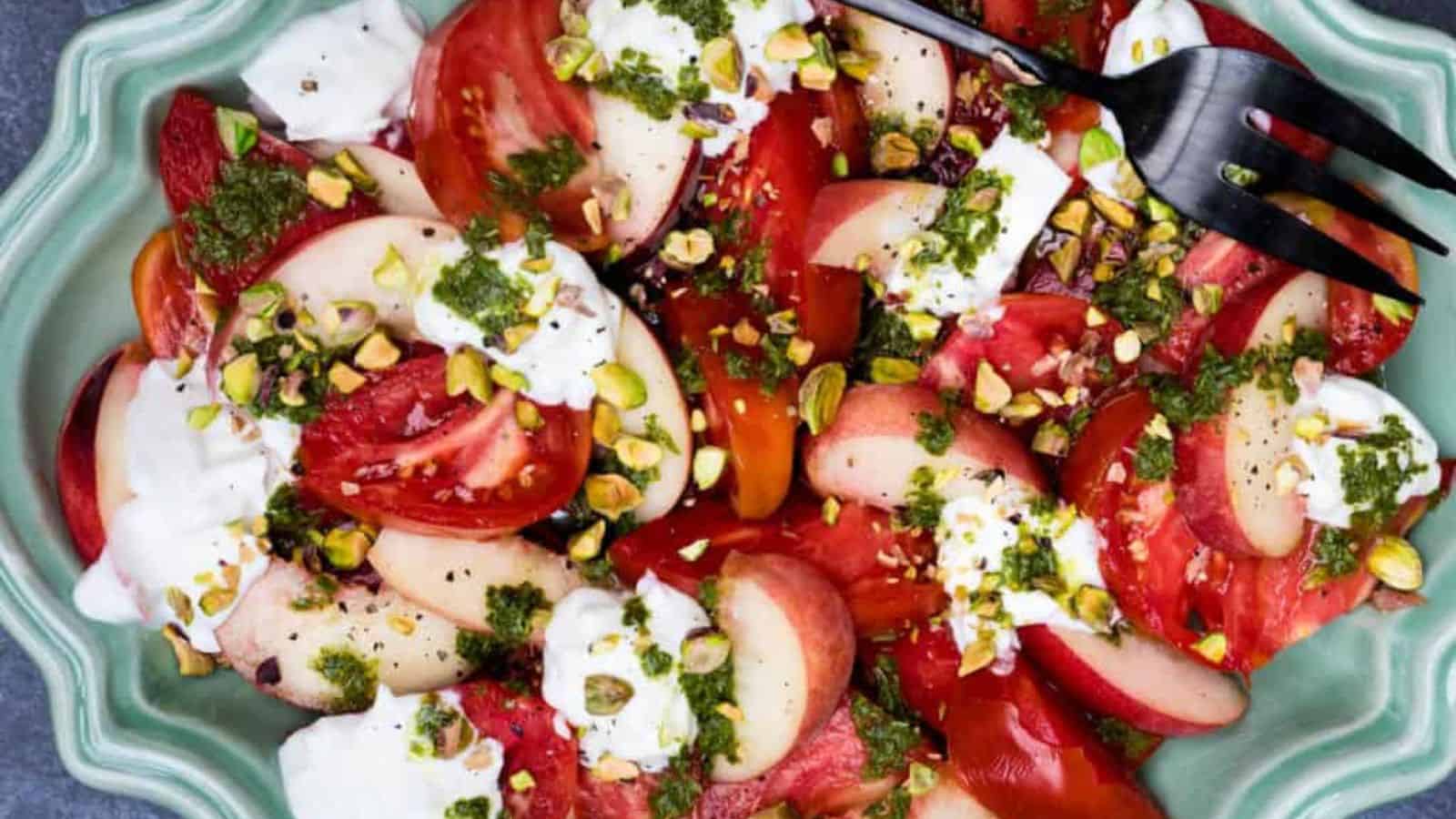 Platter with burrata caprese salad with serving fork.