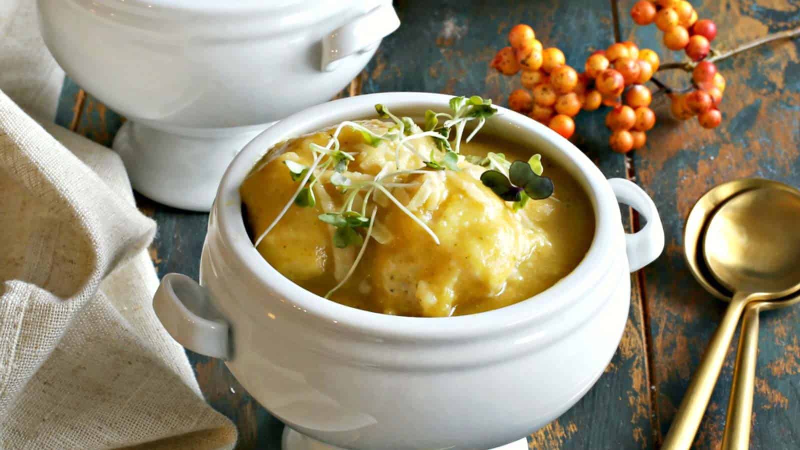 Two bowls of butternut squash soup on a wooden table.