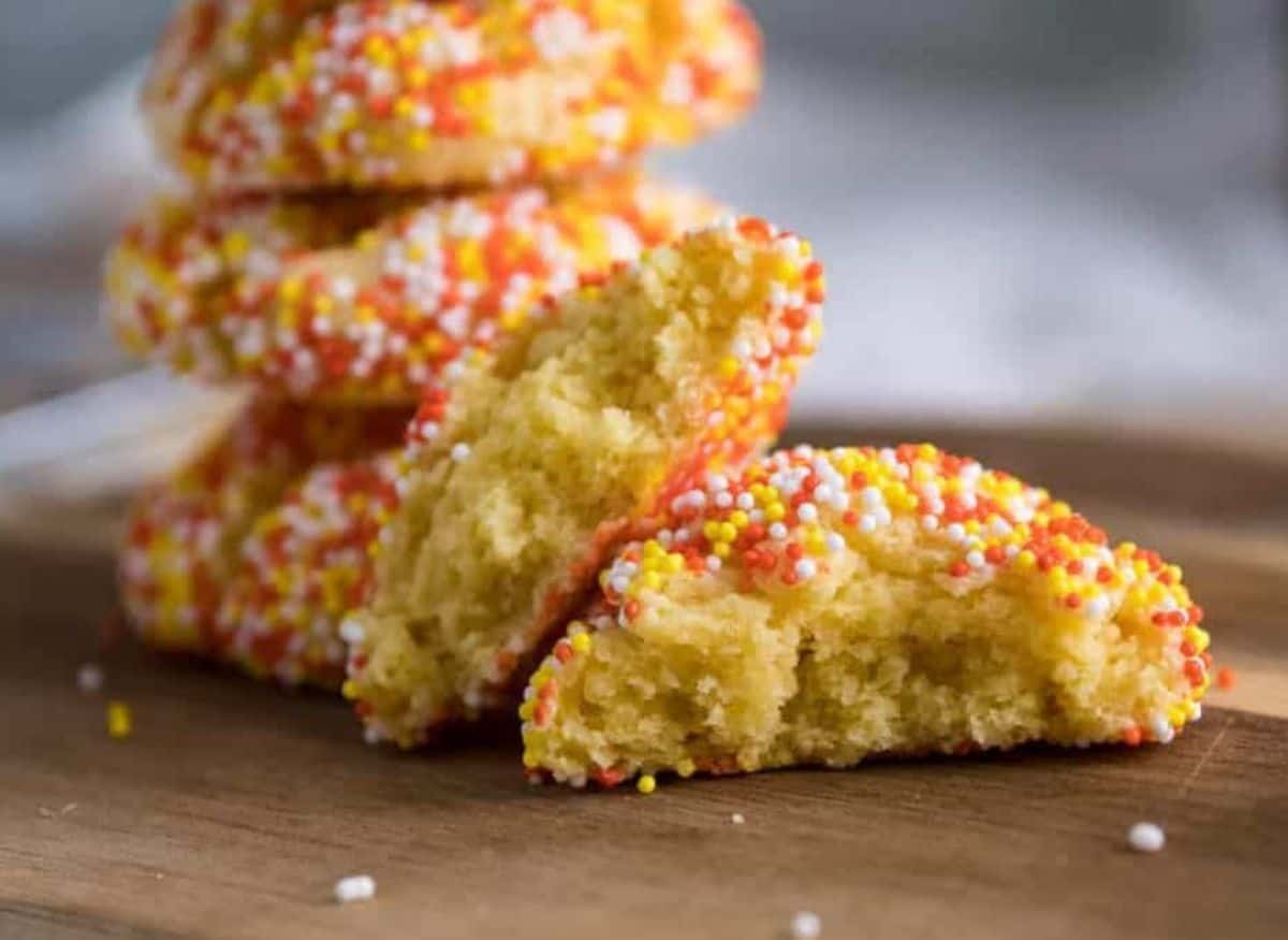 Cake Mix Cookies with Cream Cheese stacked up on a cutting board.