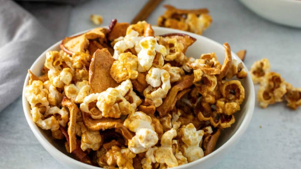 A bowl of caramel popcorn in a white bowl.