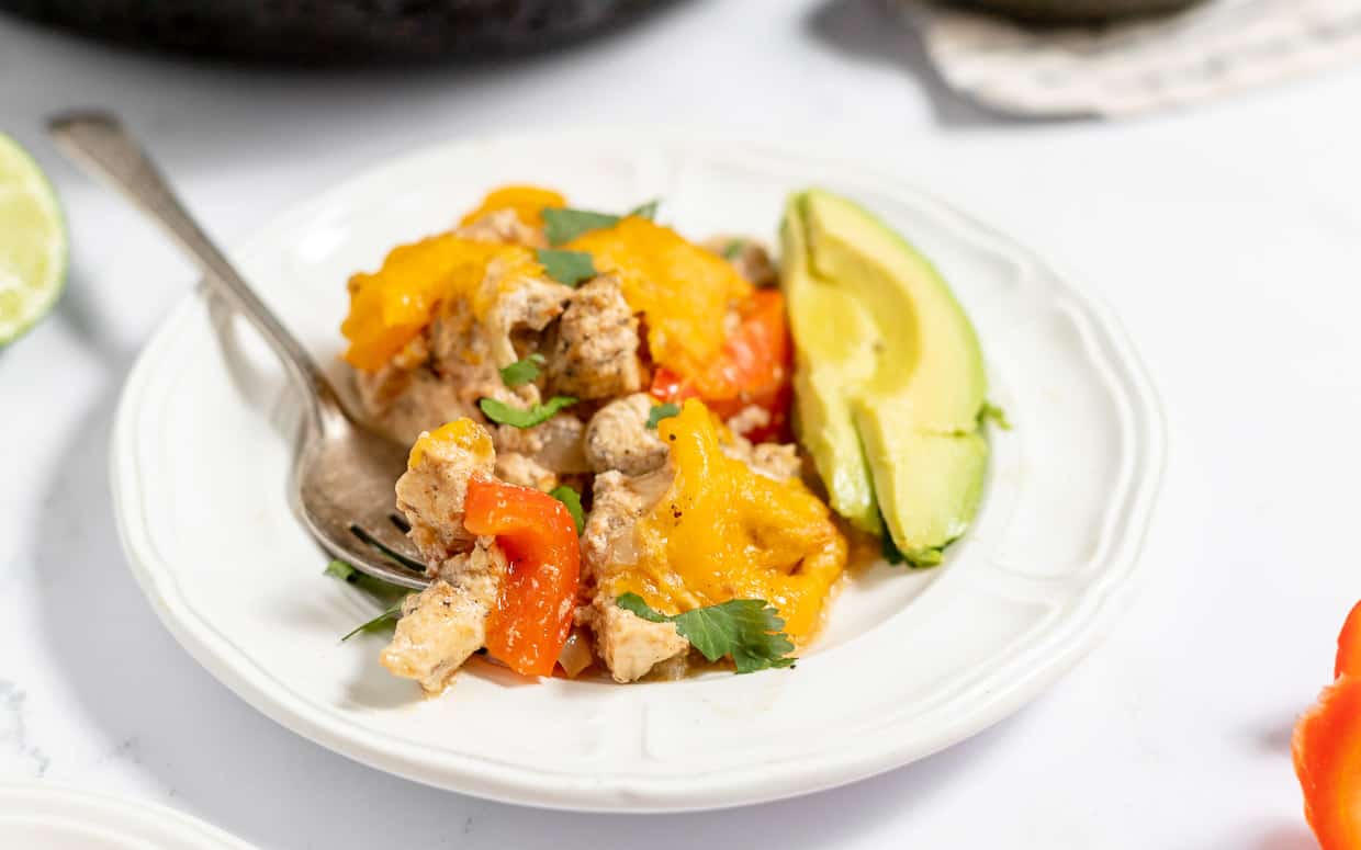 Chicken Fajita Casserole with avocado slices on the side.