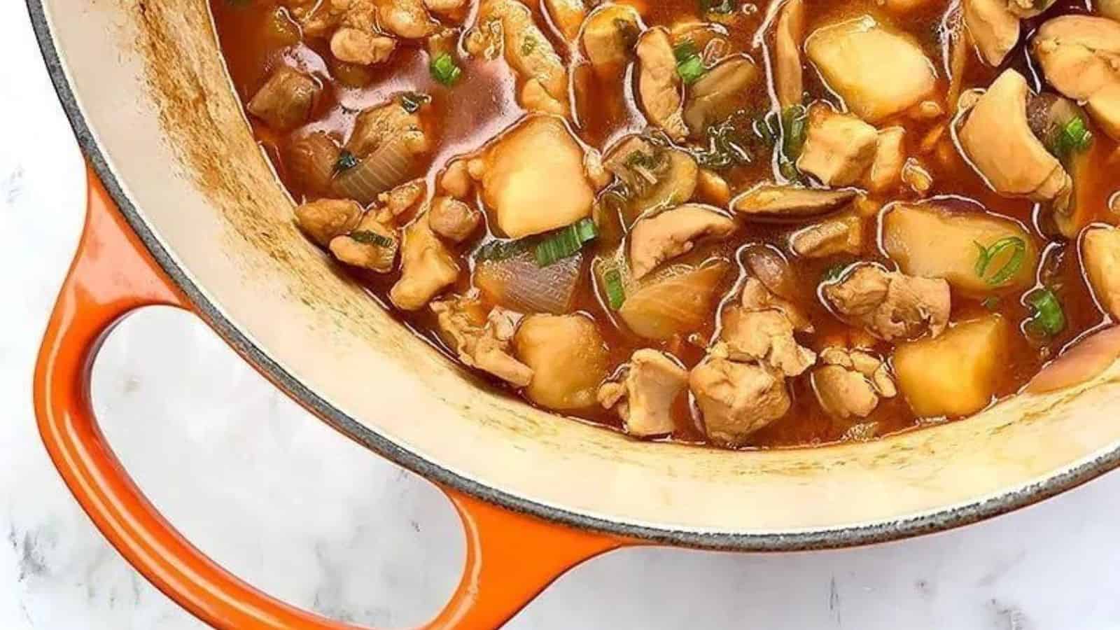 A Le Creuset Dutch oven filled with an authentic Chinese chicken & russet potato stew recipe.