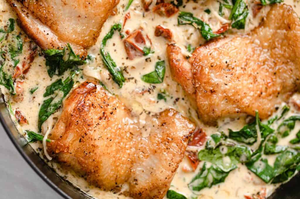 Chicken with spinach and cream sauce in a skillet.