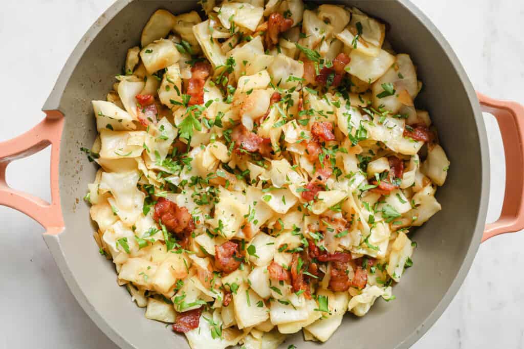 A pan with bacon and cabbage in it.