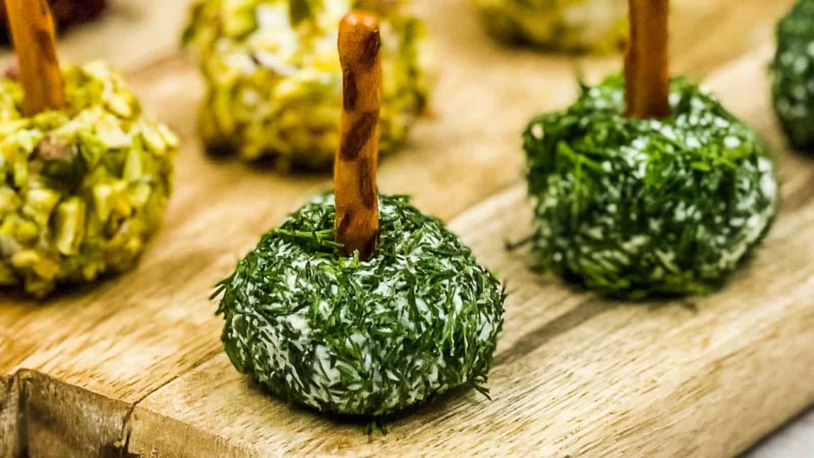 Goat cheese balls on a wooden cutting board.