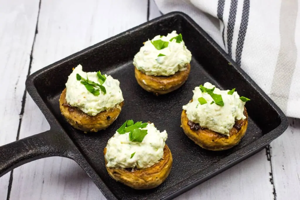 Stuffed mushrooms in a black dish.