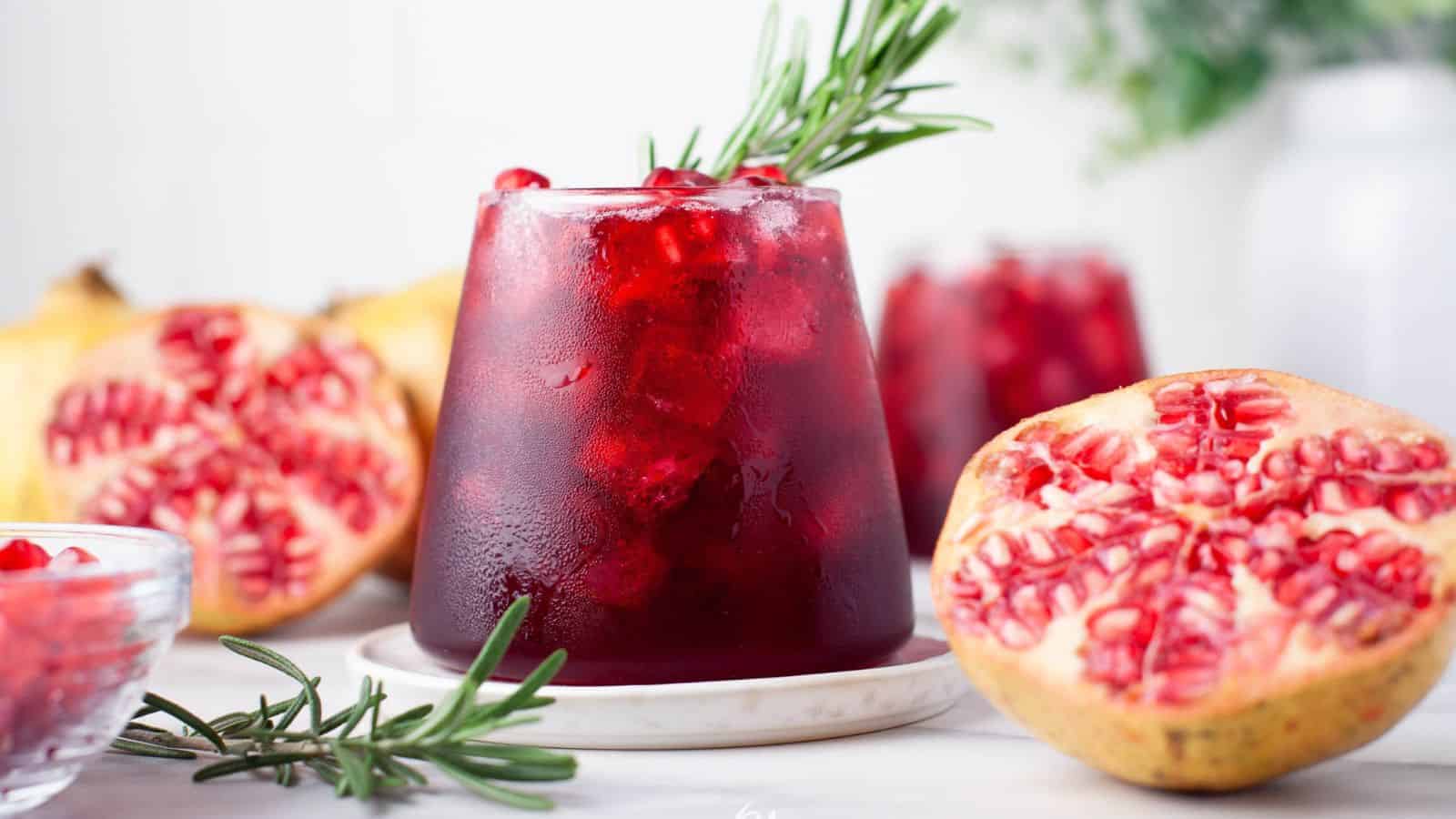 A refreshing cocktail made with pomegranate juice and garnished with rosemary sprigs.