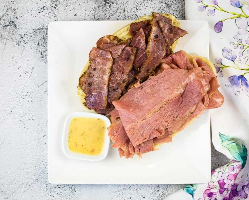 Homemade corned beef on a white plate.