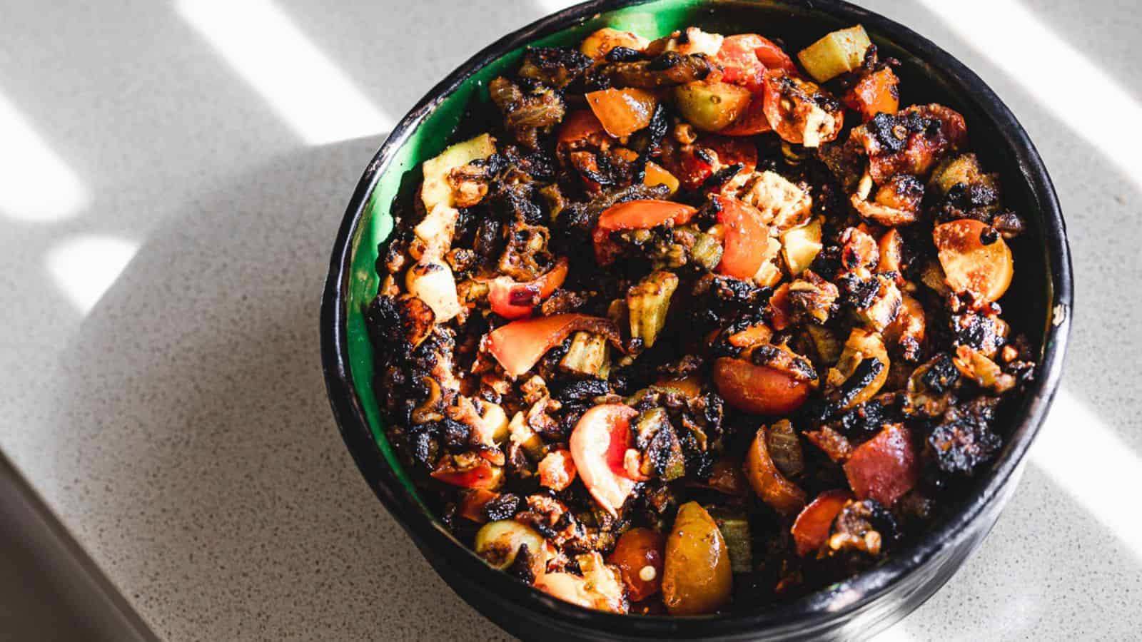 A black bowl filled with vegetables on a table.