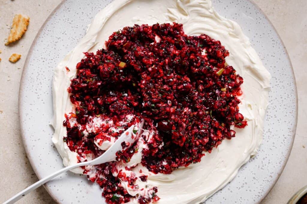 A plate of jalapeño cranberry dip with a spoon.