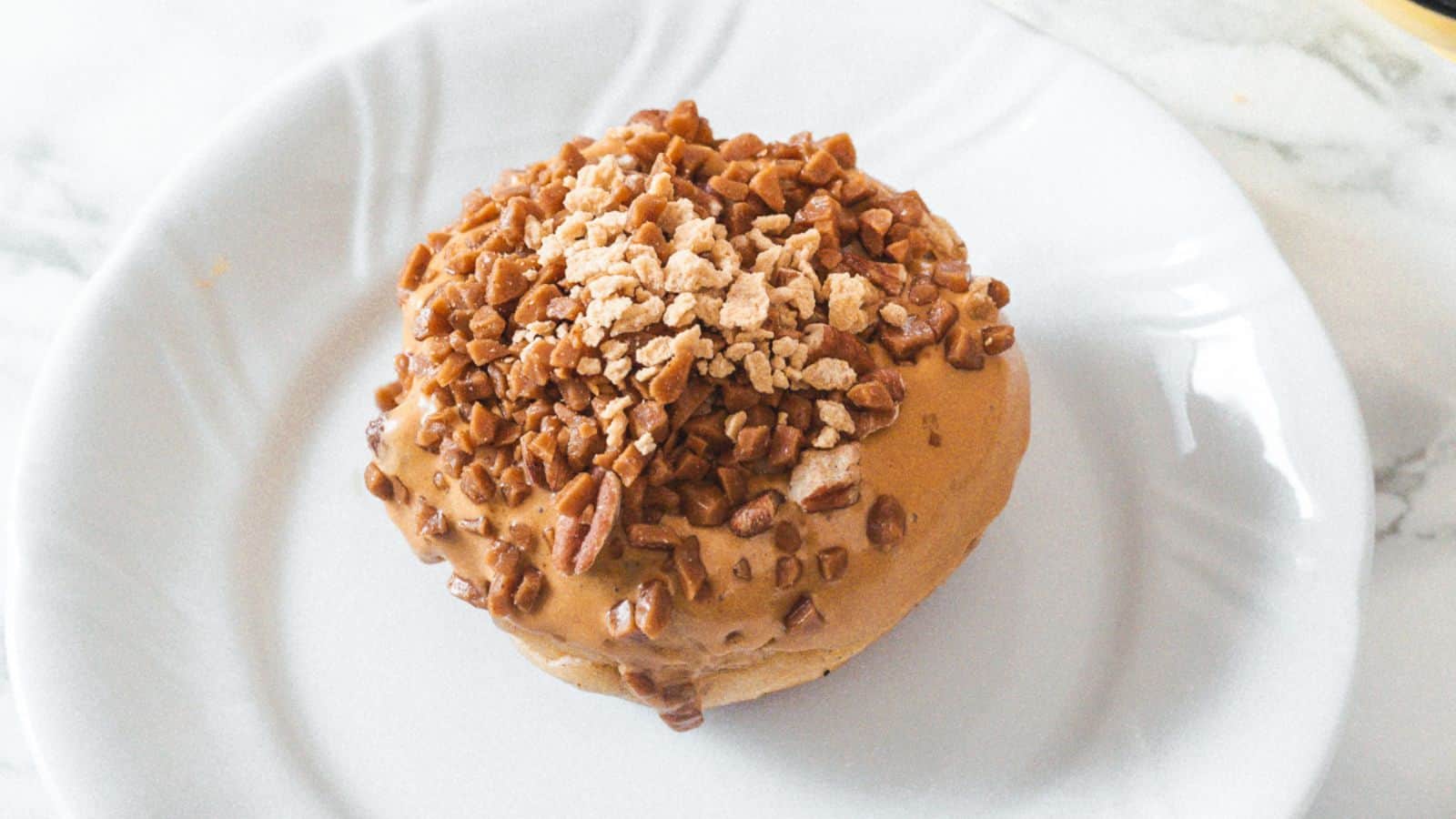 A white plate with a peanut butter doughnut on it.