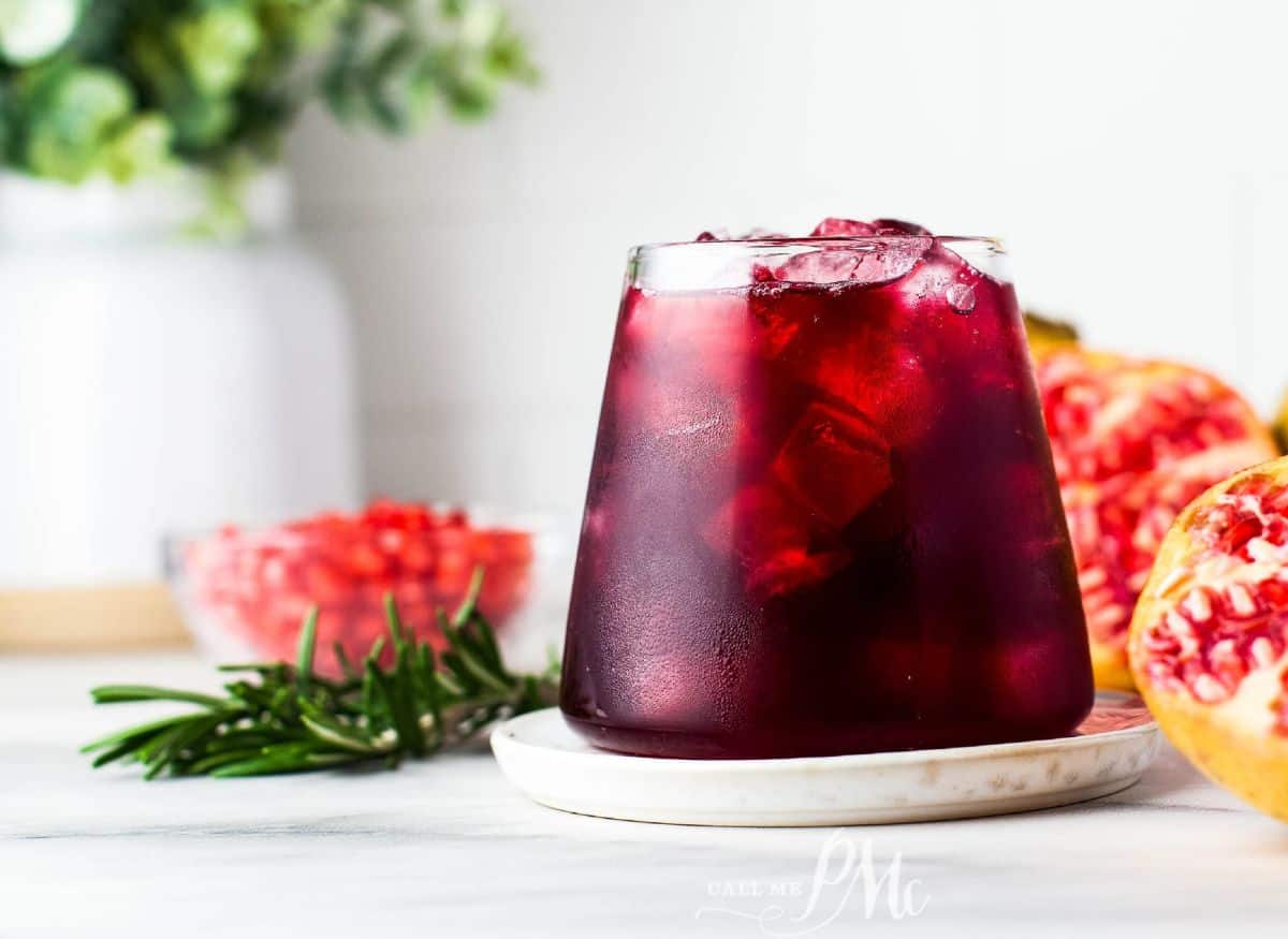 A glass of Mistletoe Margarita with rosemary and pomegranate seeds.