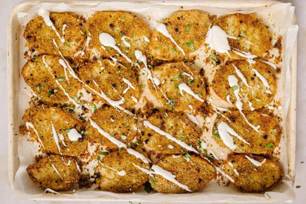 Garnished Parmesan crusted potatoes in a baking dish.