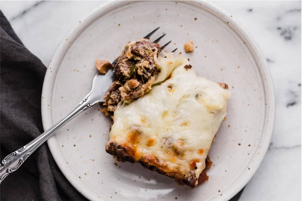 A piece of Philly cheese steak casserole on a plate with a fork.