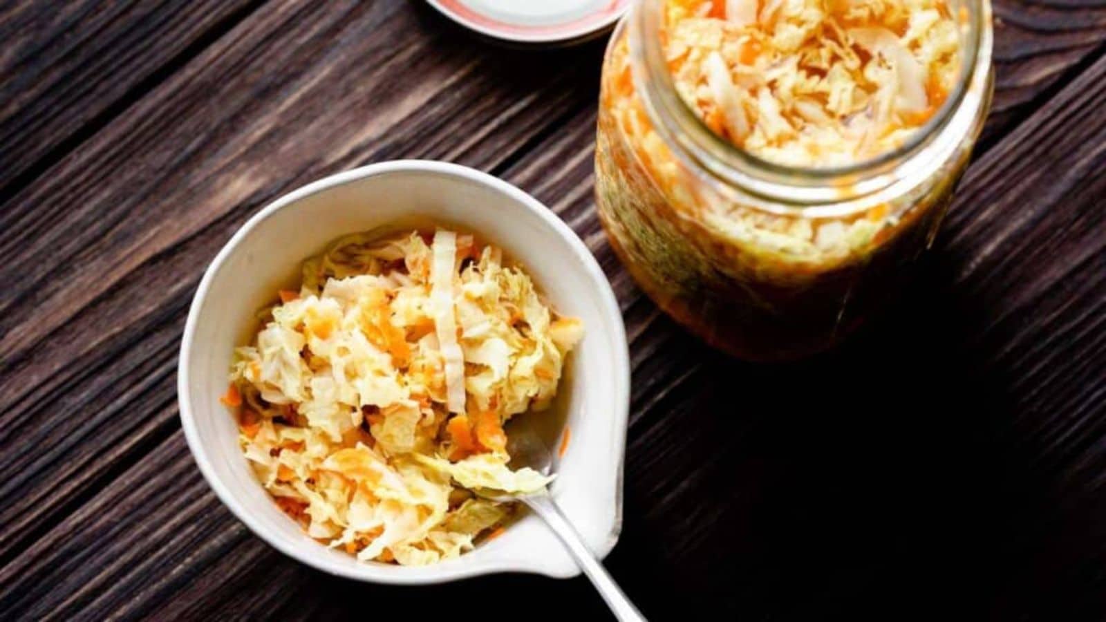 A small dish and jar filled with pickled cabbage.