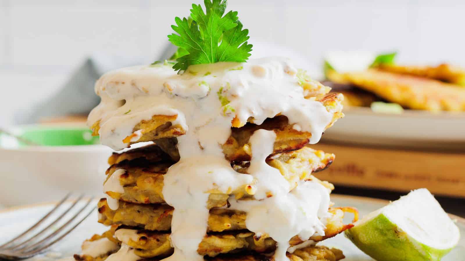 A stack of pancakes on a plate with a lime wedge.