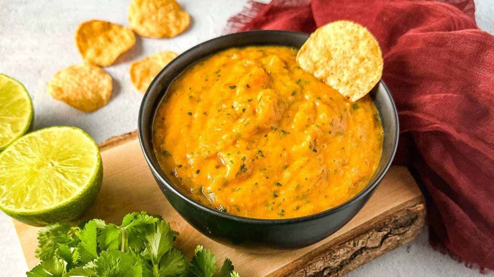 Mango habanero salsa in a black bowl with a tortilla chip.