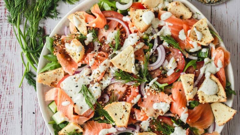 A plate of salmon salad with croutons and dill.