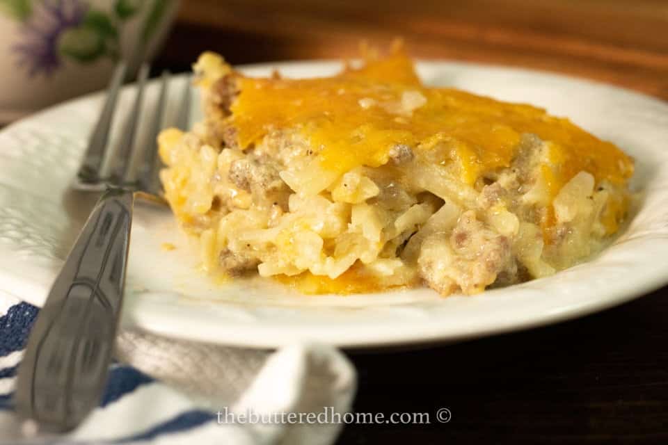 A plate with sausage hashbrown casserole on it.