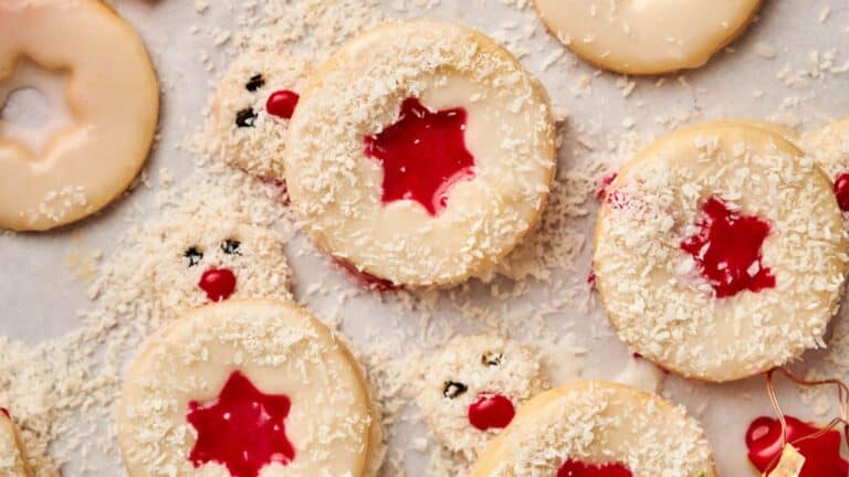 Christmas cookies with cherries and icing on a baking sheet.