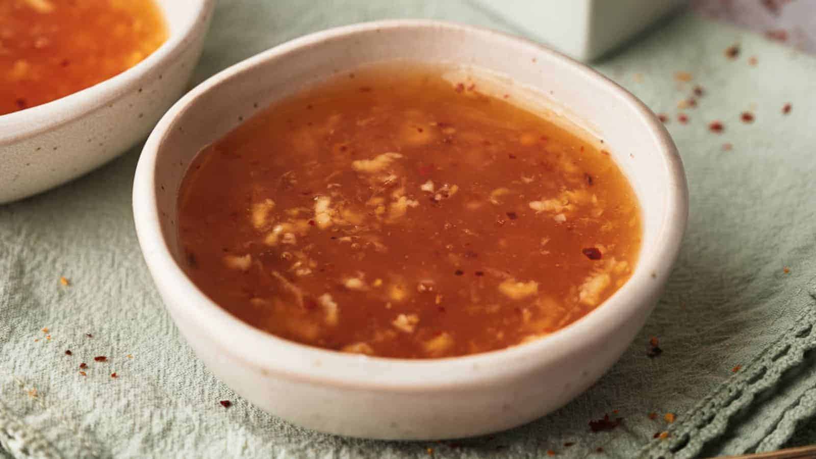 Sweet chili sauce in a small bowl on a light green cloth.