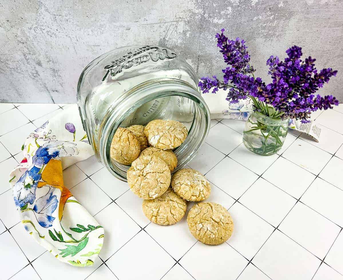 White Chocolate Crinkle Cookies spilling out of a jar.