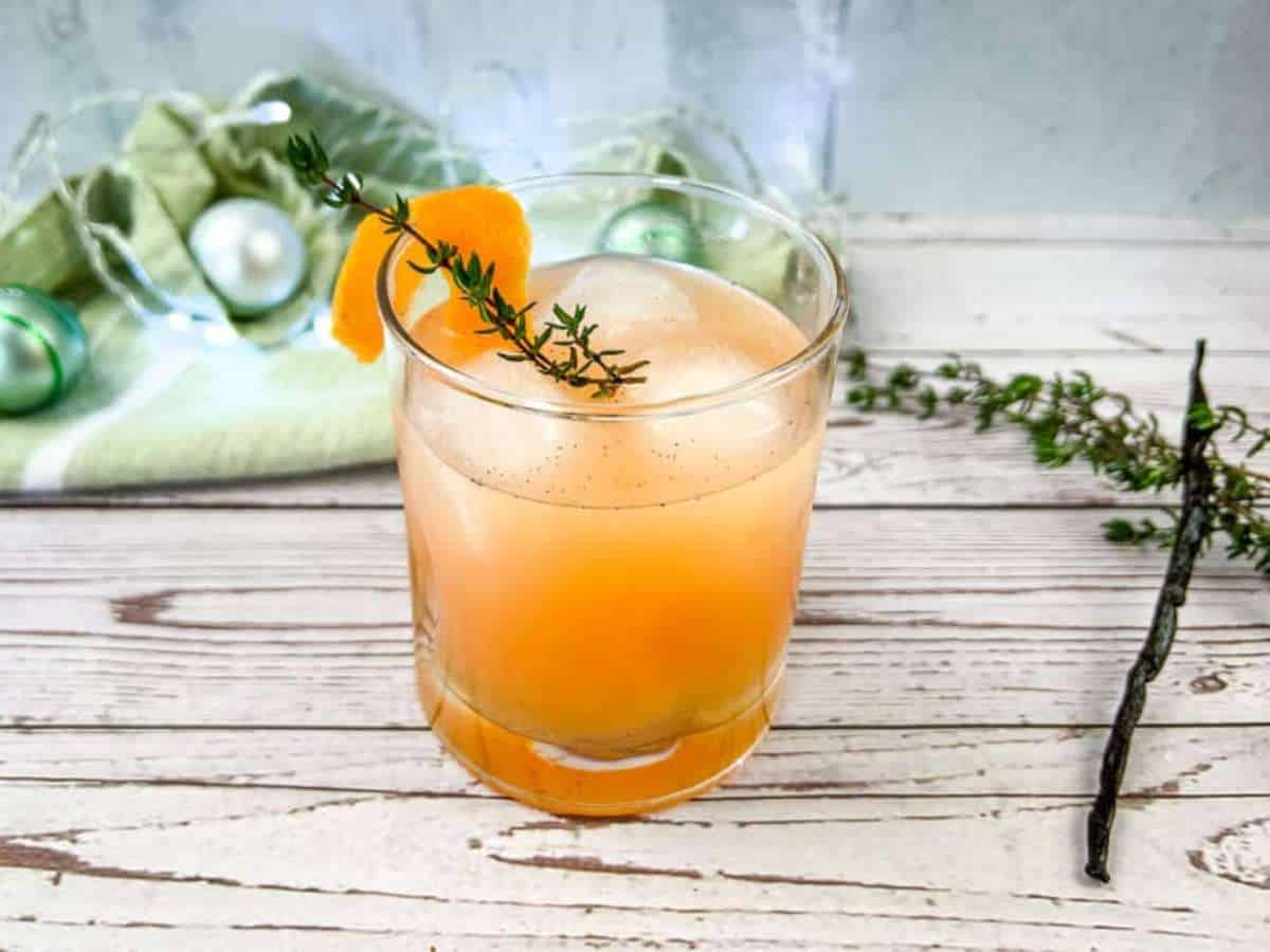 An  winter vanilla thyme vanilla paloma mocktailwith a sprig of thyme.