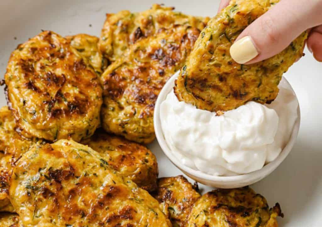 Zucchini bites with sour cream on a plate.