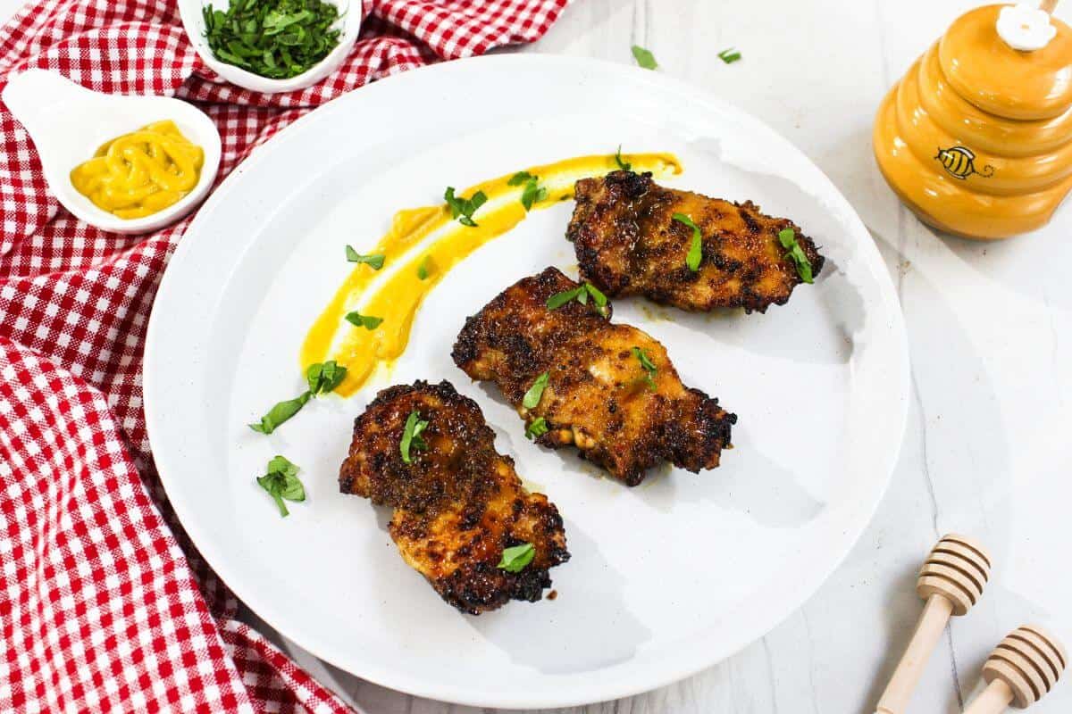 Air fried chicken with honey sauce on a white plate.