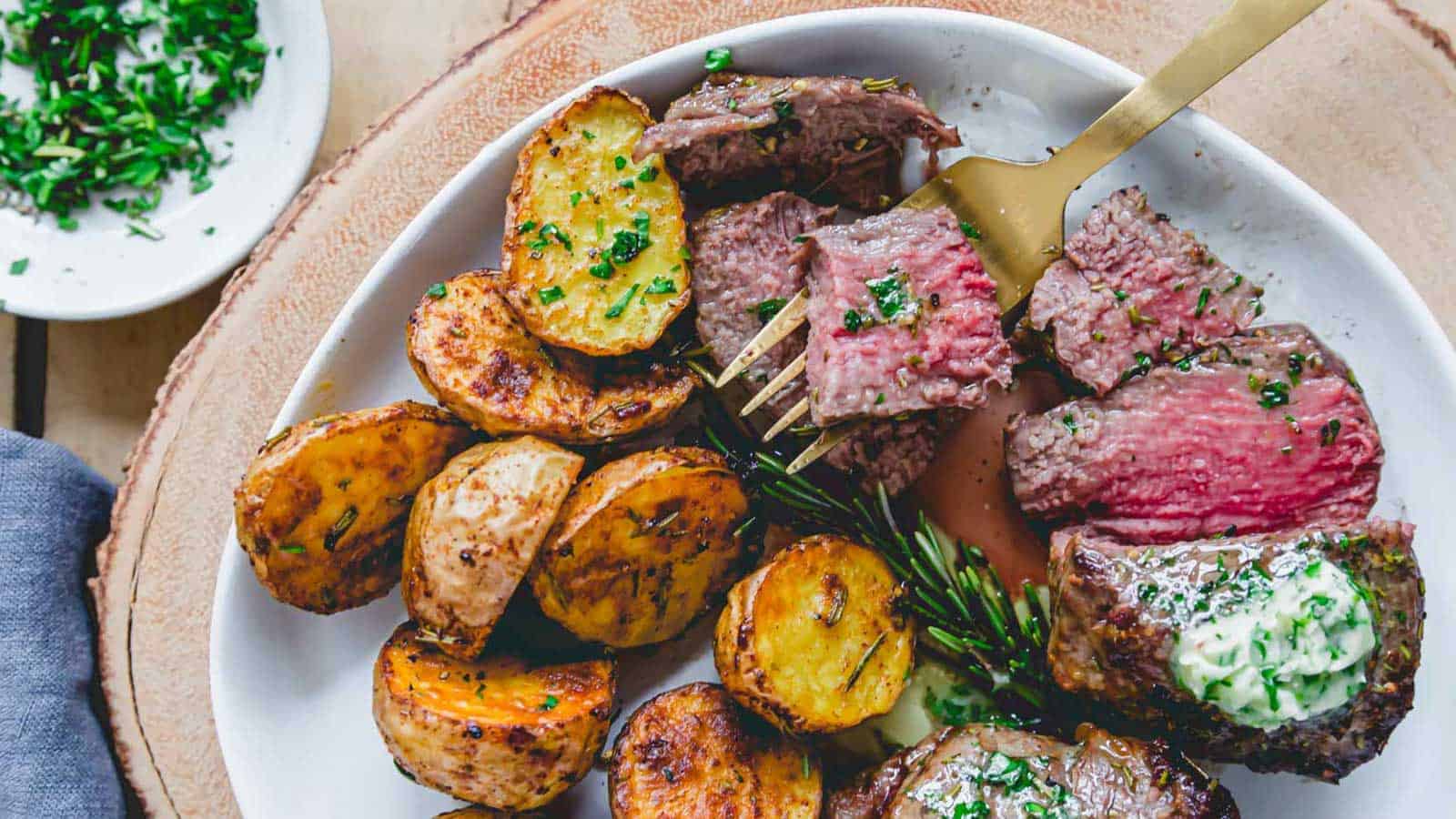 Air fryer filet mignon with sliced potatoes.