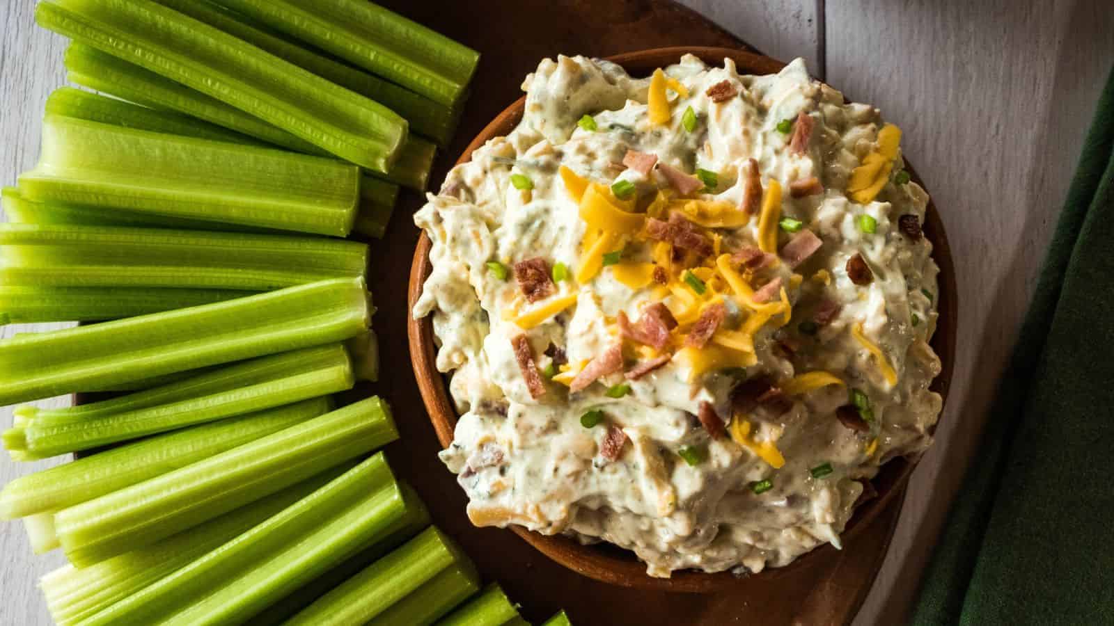 Bacon cheddar dip with shredded cheddar cheese, bacon bits, and chive garnish.