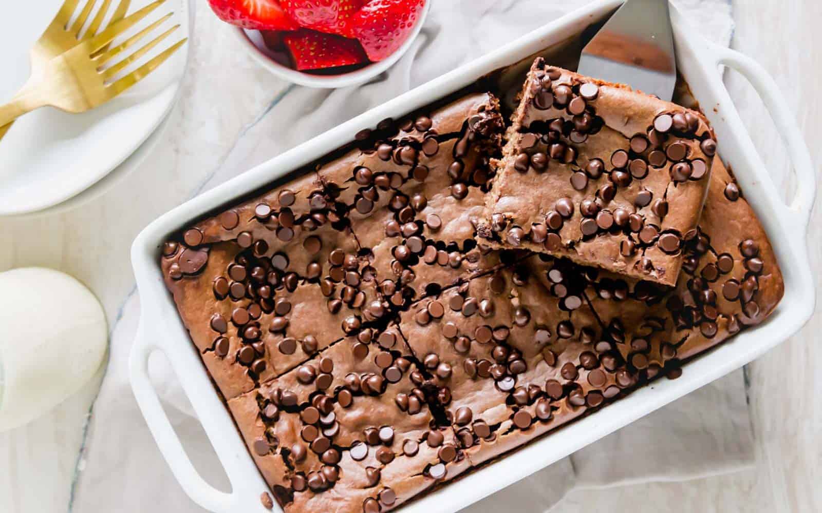 Chocolate baked oats in a white baking dish with a serving spatula.