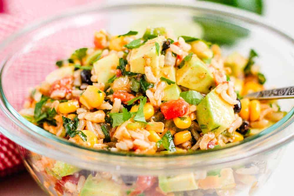 A bowl of Cowboy Caviar Salad with a serving spoon.