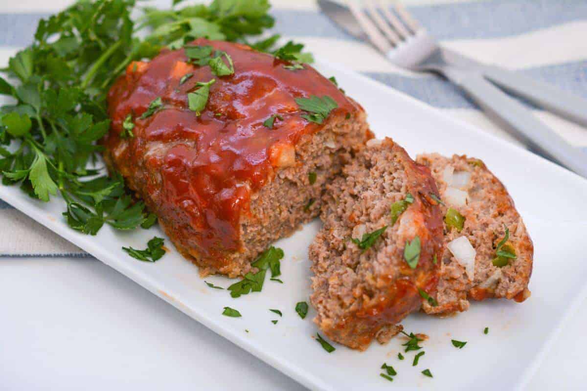 Meatloaf on a white plate with a fork.