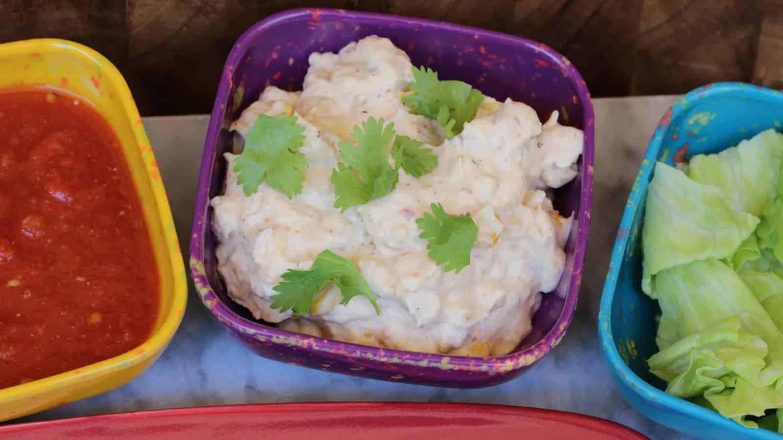 Three colorful bowls of Crockpot Mexican Street Corn Dip.