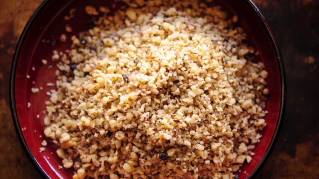 A bowl of dukkah on top of a wooden table, an edible gift for the senses.