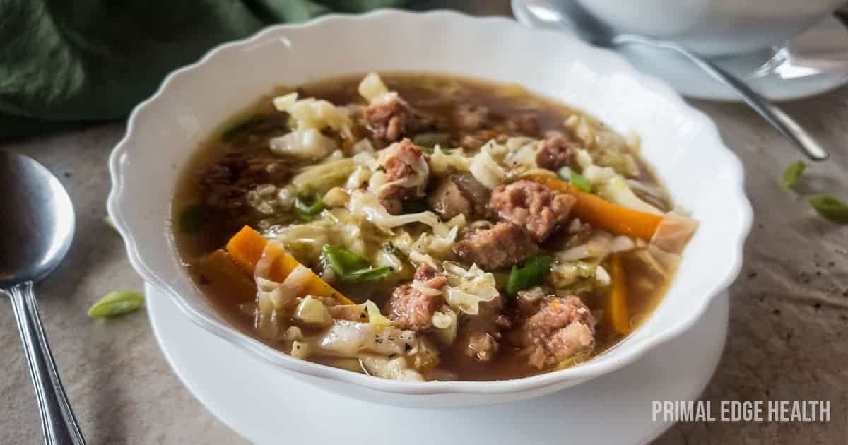 A picture of cabbage carrot sausage in broth soup..